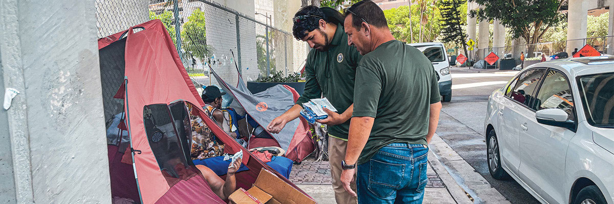 Homeless people in tents are assisted with excessive heat.