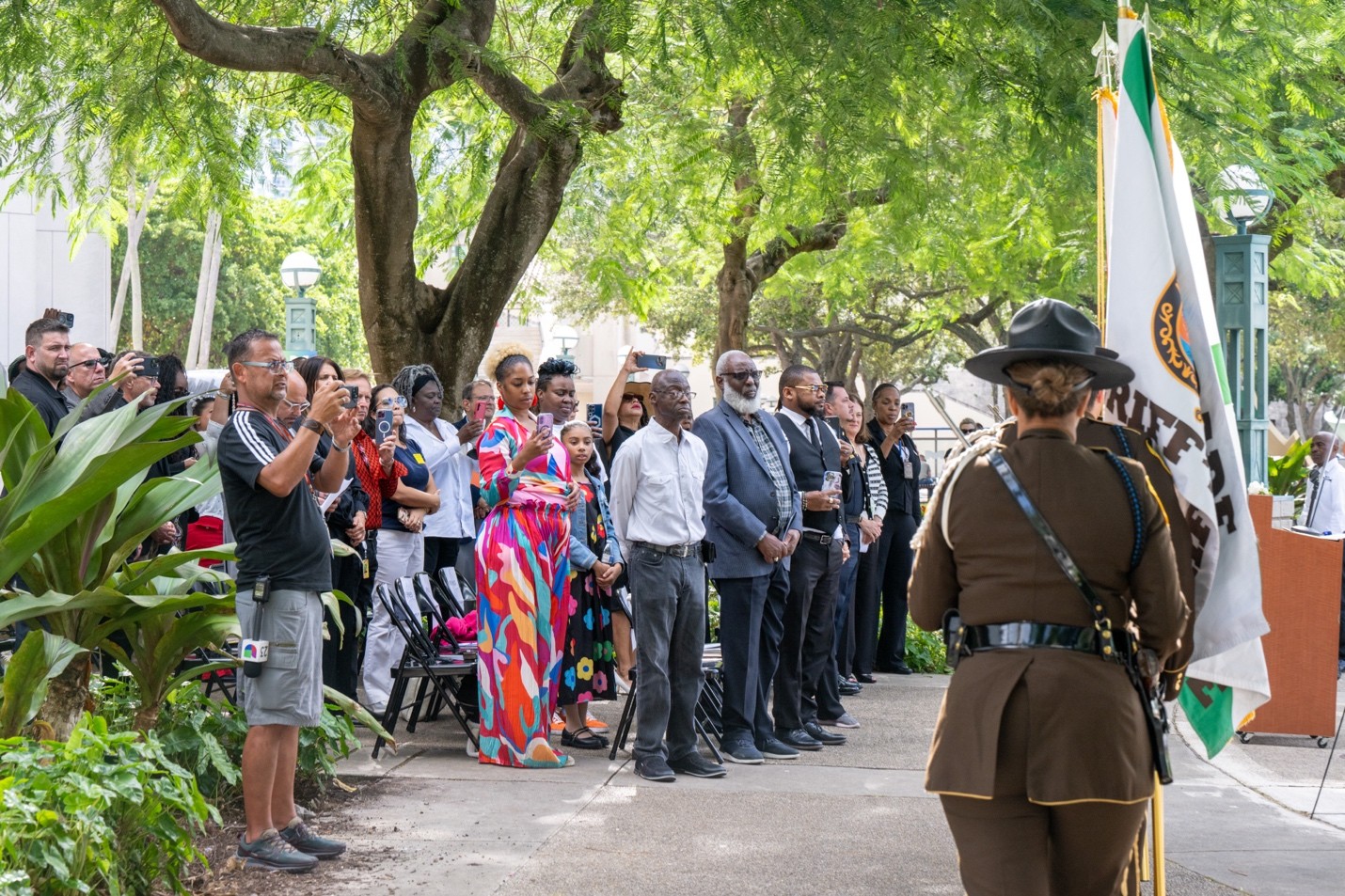 Community members stand during a Homeless Persons’ Memorial Day ceremony outdoors